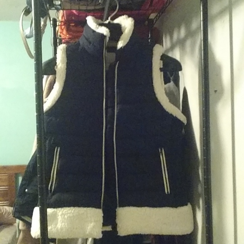 A blacker than black puffer vest with soft warm whiter than white Sherpa accents